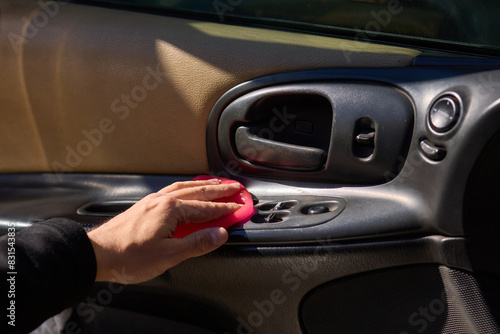A person is seen holding a pink object near the air vent of a car © Евгений Вершинин