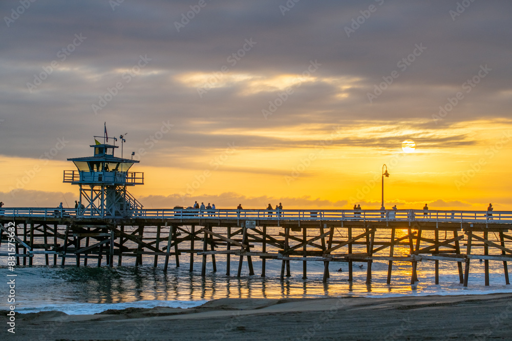 A beautiful golden beach sunset on a summer evening with people enjoying the scenery