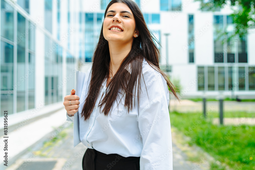 One young successful business woman going to work at business office modern building while holding coffee and papers One young successful business woman going to work at business office modern building while holding coffee and papers