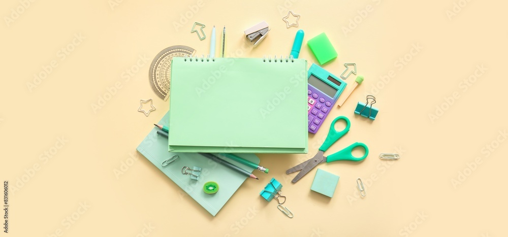 Composition with blank notebook and different school stationery on beige background Composition with blank notebook and different school stationery on beige background