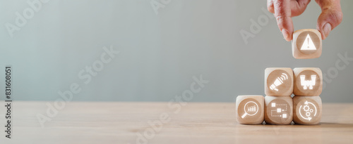 Quadro su tela Incident management concept, Hand holding wooden block on desk with incident, alert, investigation, analysis, identify and restore icon on virtual screen