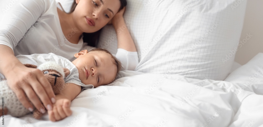 Adorable baby sleeping with toy and mother on bed Adorable baby sleeping with toy and mother on bed