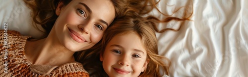 Relaxing Together: Top View of Mother and Daughter Laying on Bed