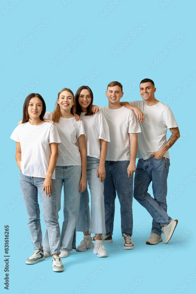 Group of young people in stylish jeans on blue background