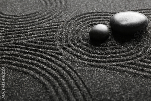 Photography Spa stones on black sand with lines, closeup. Zen concept