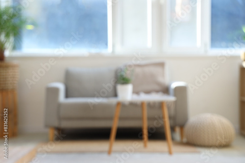 Blurred view of living room with sofa, table and window