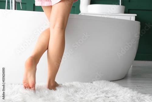 Barefoot woman in bathroom,...
