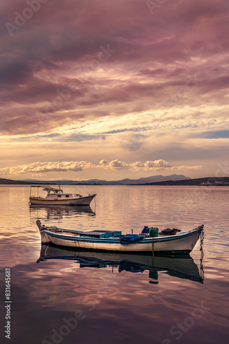 boats waiting in the reflective water clouds in the sky sunset colors © Aytug Bayer