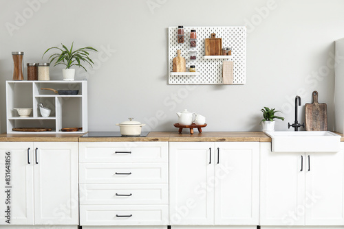 Stylish light kitchen with pegboard and kitchenware