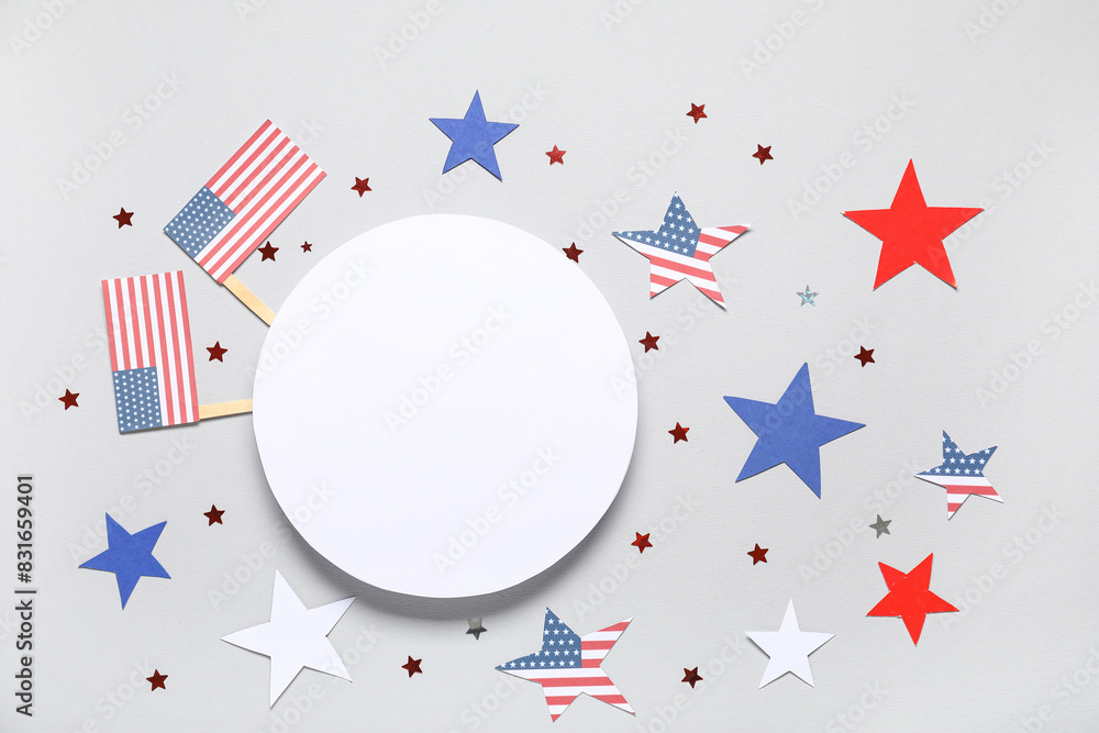Fototapeta premium Composition with blank card, USA flags and stars on grey background. Independence Day celebration