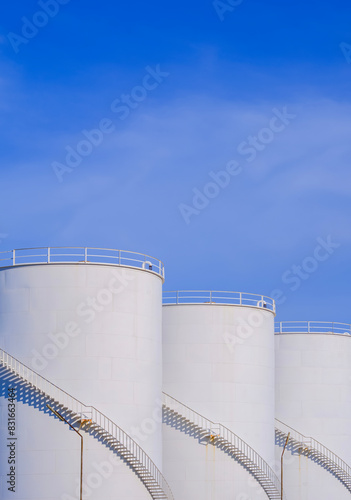 Obraz na plátně Three white storage fuel tanks in petroleum industry area against blue sky backg