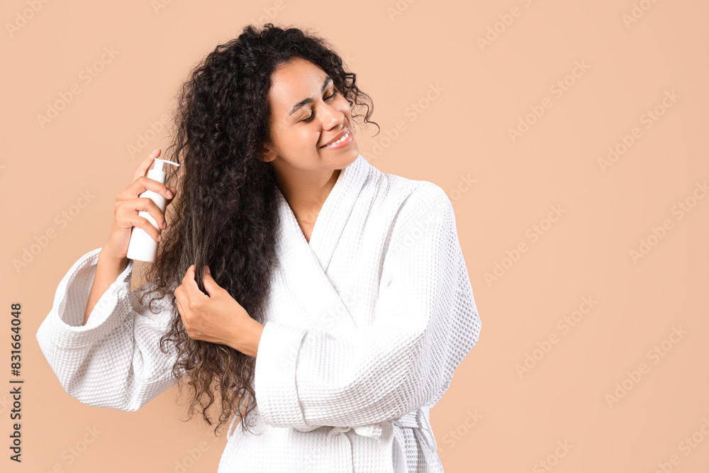 Beautiful young happy African-American woman with healthy curly hair and cosmetic product on beige background Beautiful young happy African-American woman with healthy curly hair and cosmetic product on beige background