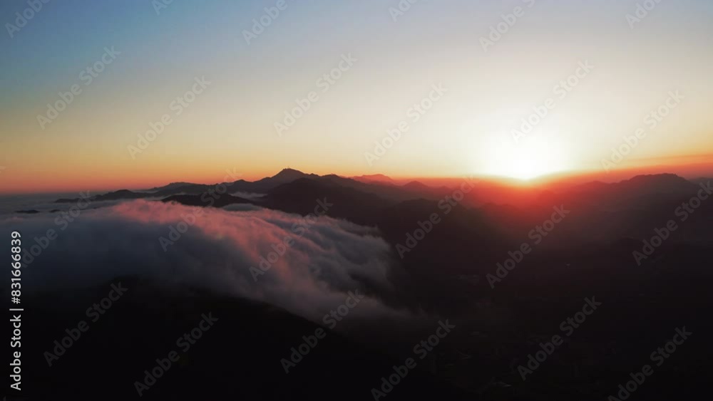 Aerial Panning Shot Of Tranquil Mountains In Fluffy Clouds Against Orange Sky At Sunset - Calico Bluff, Alaska Aerial Panning Shot Of Tranquil Mountains In Fluffy Clouds Against Orange Sky At Sunset - Calico Bluff, Alaska