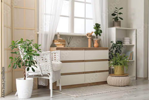 Interior of stylish living room with armchair  window and chest of drawers