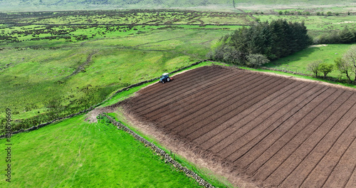 Wall Mural Aerial view of a Ford 6610 tractor rotovating a ploughed field for crops at Magi