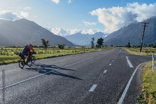 Billede på lærred Cyclists on country road leading into the Southern Alp mountain range