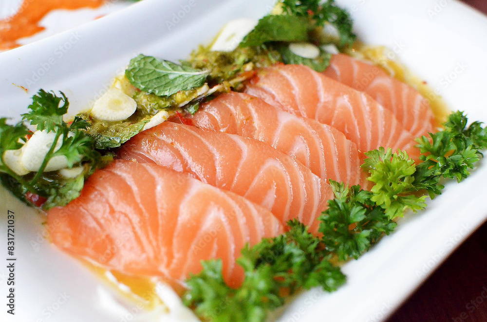 sliced salmon with parsley leaf in the white plate isolated on white background sliced salmon with parsley leaf in the white plate isolated on white background