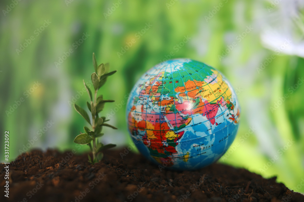 Globe With Little Tree On The Ground Againts Nature Background. Save The World. Earth Day Globe With Little Tree On The Ground Againts Nature Background. Save The World. Earth Day