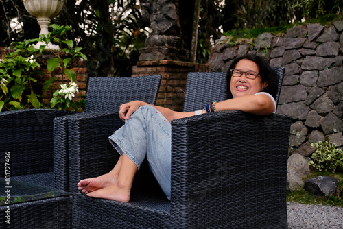 Woman enjoying her free evening sitting on garden chair at the backyard photo