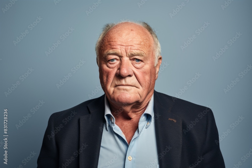 Portrait of a senior man looking at camera. Isolated on blue background. Portrait of a senior man looking at camera. Isolated on blue background.