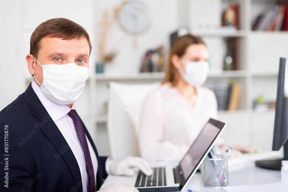Φωτογραφία Portrait of confident manager wearing medical mask and protective gloves working with female colleague in office