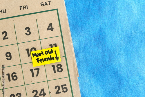 Meet old friends and reconnection schedule concept. Written reminder note on calendar.	