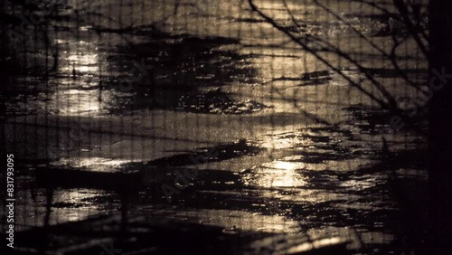Heavy Rain On Asphalt At Night With Street Light Reflection Behind Fence - Static photo