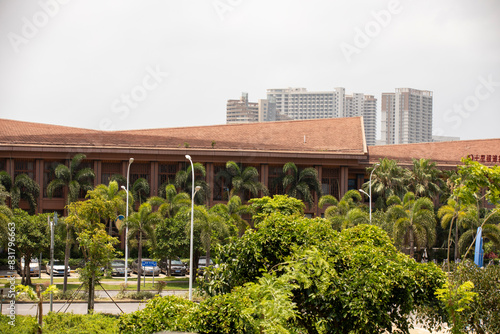 Contemporary urban structure surrounded by trees, with a city skyline in the distance