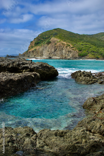 Coastal landscape with crystal clear blue ocean and rocky shoreline in rural New Zealand 