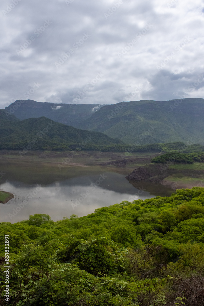 Aerial view of the Choix natural dam, with a cloudy background and green mountains Aerial view of the Choix natural dam, with a cloudy background and green mountains