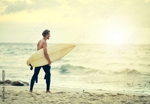 Photography Surfer, walking and man on beach at sunset for adventure in summer, holiday or travel in vacation