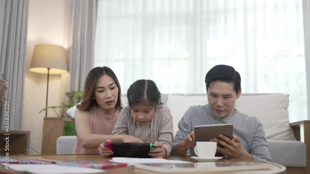 Daughter is playing video game along side with her parents at home. Daughter is playing video game along side with her parents at home.