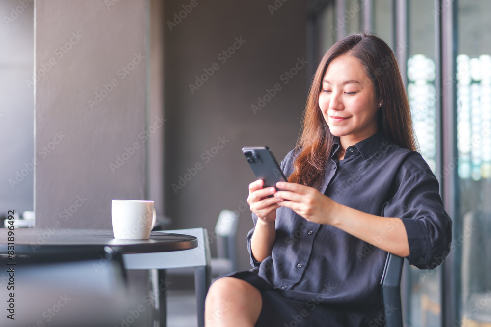Portrait image of a young woman holding and using mobile phone in cafe Portrait image of a young woman holding and using mobile phone in cafe