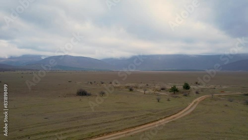 A beautiful landscape drone video of an empty field with a road in Croatia region Lika in Europe (ID: 831898499)