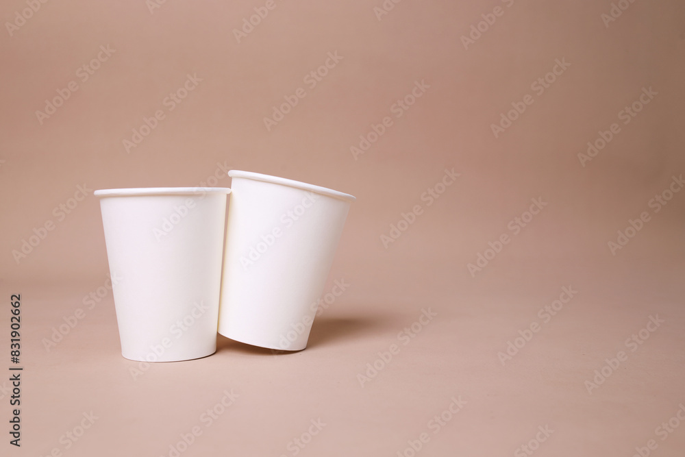 Close Up Of Two Blank White Paper Cup For Mockup With Copy Space Over Beige Background Close Up Of Two Blank White Paper Cup For Mockup With Copy Space Over Beige Background