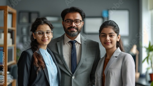 Indian male and female colleagues Business goes hand in hand with the boss. Place the camera over a gray wall in the office.