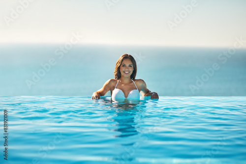Portrait  girl and relax in swimming pool with happiness for luxury vacation by resort  tropical and travel adventure for peace. Woman  swimsuit and confident outdoor on holiday for sunshine in Bali.