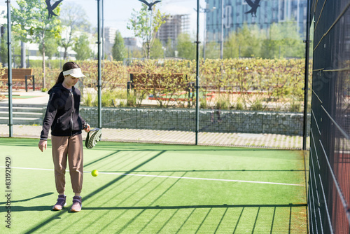 Photography little girl playing padel and hitting the ball with his racket outdoors sports