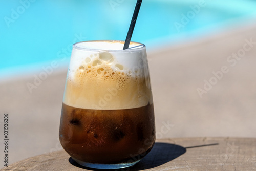 View of a delicious iced greek coffee, also known as freddo cappuccino with a straw in Ios Greece