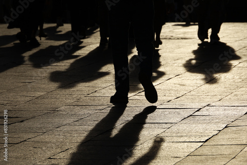 Black silhouettes and shadows of people on the street. Crowd walking down on sidewalk, concept of pedestrians, crime, society, city life