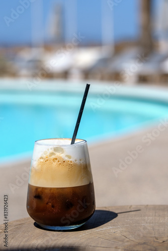View of a delicious iced greek coffee, also known as freddo cappuccino with a straw in Ios Greece