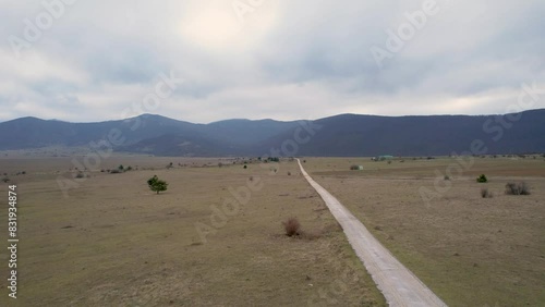 A beautiful landscape drone video of an empty field with a road in Croatia region Lika in Europe (ID: 831934874)