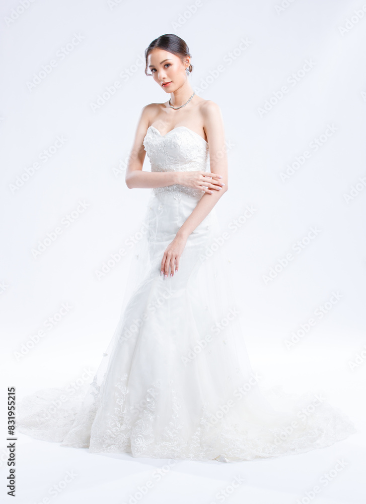 Asian young beautiful female portrait attractive model of bride wearing fashion wedding dress, luxury delight make-up, hairstyle, standing looking camera isolated white background studio indoor photo Asian young beautiful female portrait attractive model of bride wearing fashion wedding dress, luxury delight make-up, hairstyle, standing looking camera isolated white background studio indoor photo