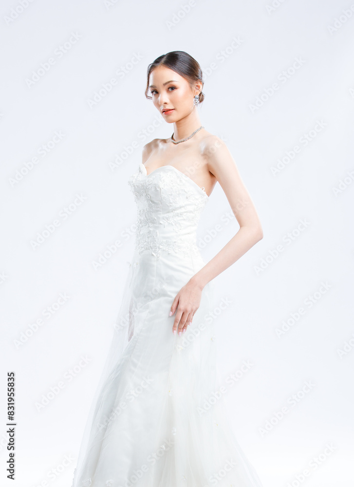 Asian young beautiful female portrait attractive model of bride wearing fashion wedding dress, luxury delight make-up, hairstyle, standing looking camera isolated white background studio indoor photo Asian young beautiful female portrait attractive model of bride wearing fashion wedding dress, luxury delight make-up, hairstyle, standing looking camera isolated white background studio indoor photo