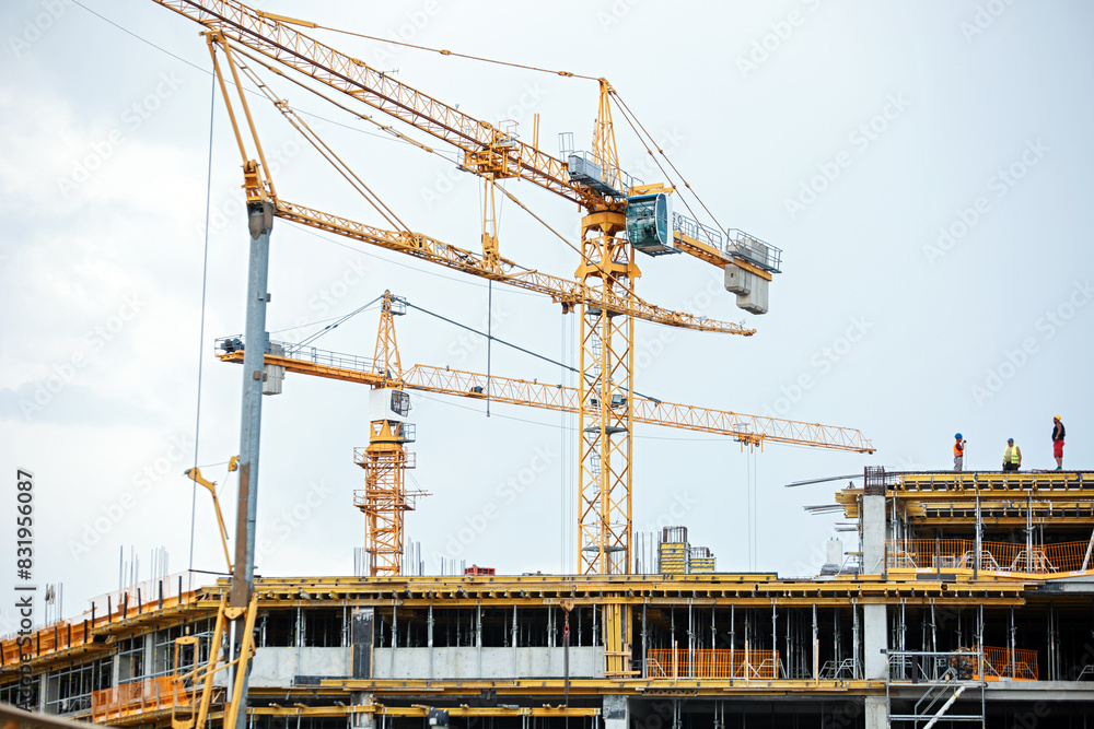 View of a construction site with buildings under construction and multi-storey residential homes. View of a construction site with buildings under construction and multi-storey residential homes.