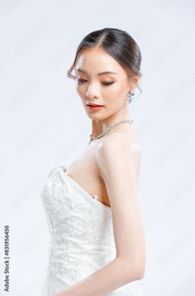 Asian young beautiful female portrait attractive model of bride wearing fashion wedding dress, luxury delight make-up, hairstyle, standing looking camera isolated white background studio indoor photo Asian young beautiful female portrait attractive model of bride wearing fashion wedding dress, luxury delight make-up, hairstyle, standing looking camera isolated white background studio indoor photo