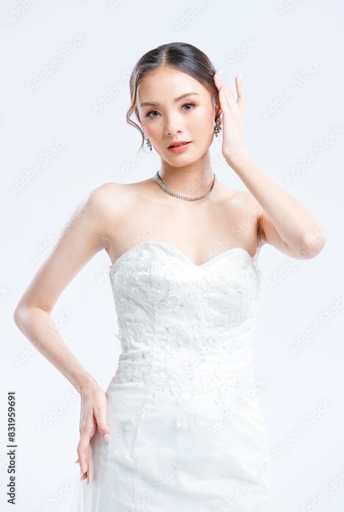 Asian young beautiful female portrait attractive model of bride wearing fashion wedding dress, luxury delight make-up, hairstyle, standing looking camera isolated white background studio indoor photo Asian young beautiful female portrait attractive model of bride wearing fashion wedding dress, luxury delight make-up, hairstyle, standing looking camera isolated white background studio indoor photo
