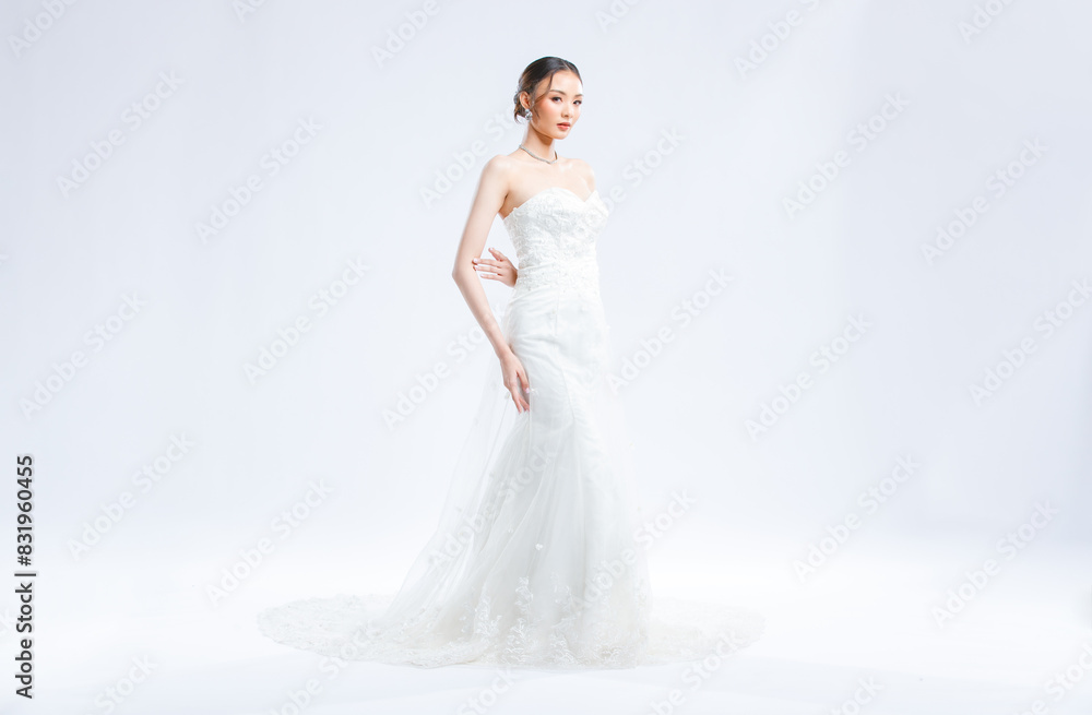 Asian young beautiful female portrait attractive model of bride wearing fashion wedding dress, luxury delight make-up, hairstyle, standing looking camera isolated white background studio indoor photo Asian young beautiful female portrait attractive model of bride wearing fashion wedding dress, luxury delight make-up, hairstyle, standing looking camera isolated white background studio indoor photo