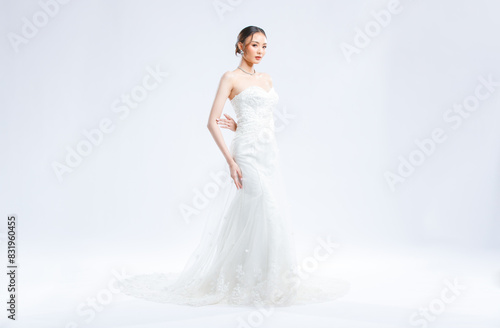 Asian young beautiful female portrait attractive model of bride wearing fashion wedding dress, luxury delight make-up, hairstyle, standing looking camera isolated white background studio indoor photo