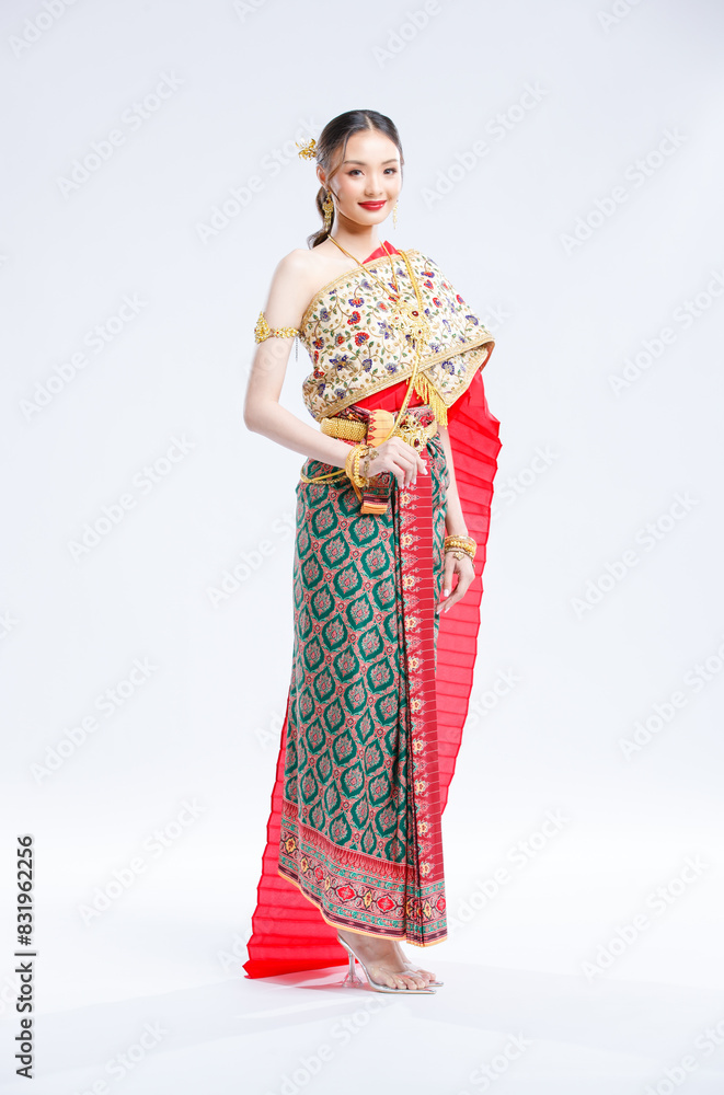 Asian young female portrait beautiful bride woman in vintage traditional Thai costumes, gold and red color dress, standing smile looking camera isolated white background studio Asian young female portrait beautiful bride woman in vintage traditional Thai costumes, gold and red color dress, standing smile looking camera isolated white background studio